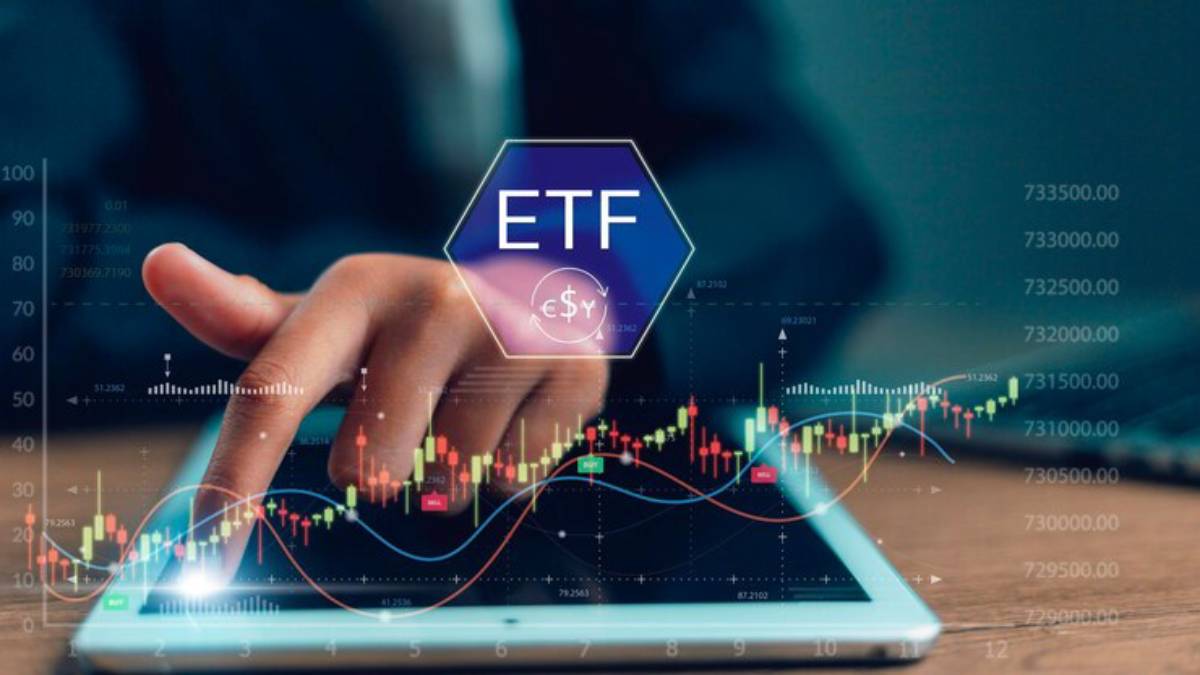 A person’s hand interacts with a tablet displaying financial charts and the term ETF, symbolizing investment analysis.