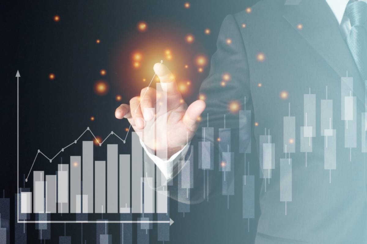 A businessman in a suit interacts with glowing data visuals and stock charts, symbolizing financial growth and analysis.