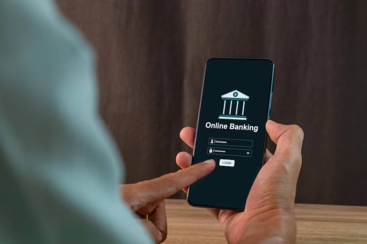 A person using a smartphone to access online banking, entering username and password on a login screen.